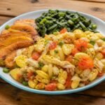 Jamaican ackee and saltfish with tomatoes, peppers, scallions, fried plantain, and greens.