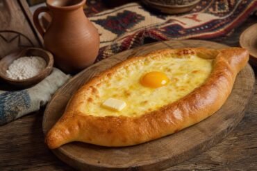 Georgian boat-shaped khachapuri filled with melted cheese, a soft egg yolk, and butter.