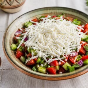 Bulgarian shopska salad with tomatoes, cucumber, peppers, parsley, and grated white cheese.