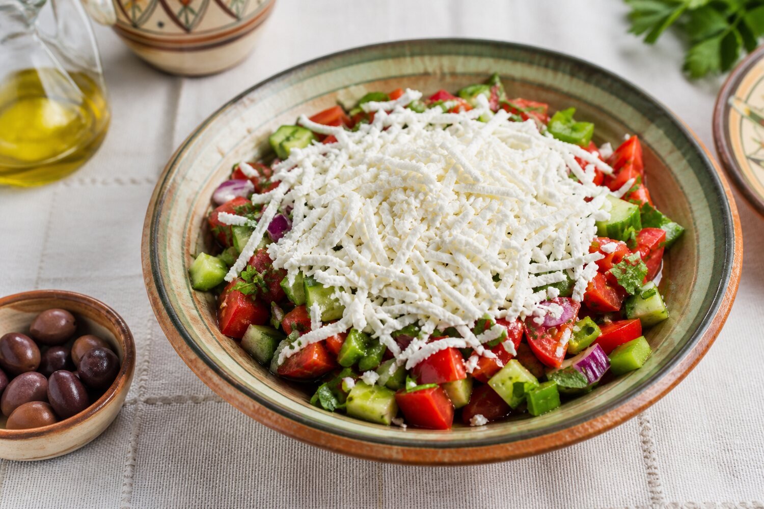 Bulgarian shopska salad with tomatoes, cucumber, peppers, parsley, and grated white cheese.