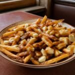 Quebec-style poutine with crisp fries, fresh cheese curds, and glossy brown gravy.