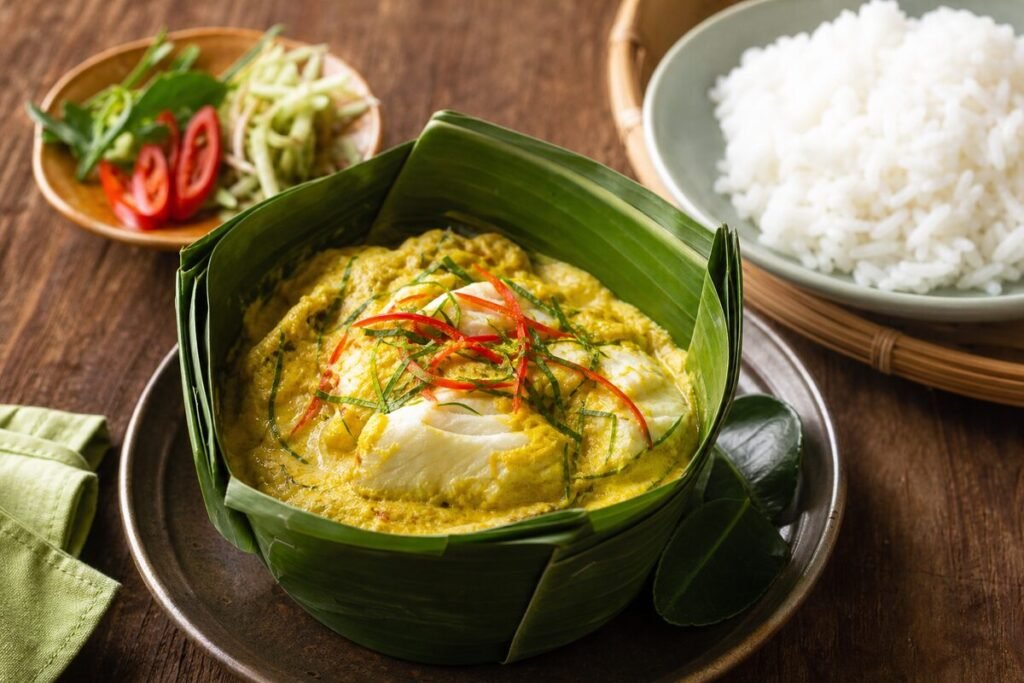 Cambodian fish amok with tender white fish in silky coconut custard, kaffir lime, herbs, and banana leaf.