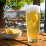 A chilled German radler made with pale lager and sparkling lemonade with lemon wedges.