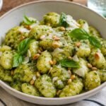 Pillowy Italian potato gnocchi coated in basil pesto with Parmesan, pine nuts, and fresh basil.