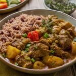 Jamaican curry goat with potatoes, scallions, thyme, curry gravy, and rice and peas.