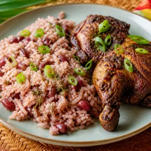 Jamaican rice and peas with coconut, red kidney beans, thyme, scallions, and jerk-seasoned chicken on a plate.