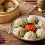Steamed Nepalese momo dumplings with tomato achar and cilantro in a bamboo steamer.