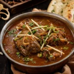 A bowl of Pakistani nihari beef stew with ginger, cilantro, green chili, and naan.