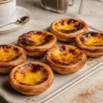 Portuguese custard tarts with caramelized tops and crisp flaky pastry.