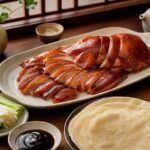 Classic Peking duck with glossy crisp skin, thin pancakes, cucumber, scallions, and hoisin sauce.