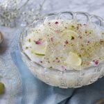 A chilled bowl of Persian faloodeh with rosewater noodles, lime, pistachios, and rose petals.