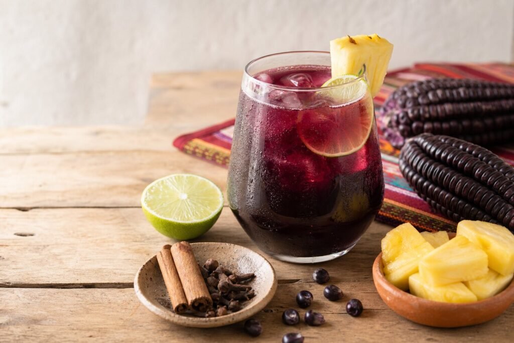 A chilled glass of Peruvian chicha morada with lime, pineapple, cinnamon, cloves, and purple corn.