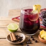 A chilled glass of Peruvian chicha morada with lime, pineapple, cinnamon, cloves, and purple corn.
