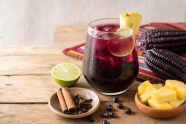 A chilled glass of Peruvian chicha morada with lime, pineapple, cinnamon, cloves, and purple corn.