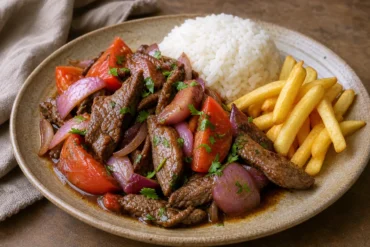 Peruvian Lomo Saltado with seared beef, red onions, tomatoes, fries, and white rice.