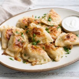 Polish pierogi ruskie with potato and cheese filling, caramelized onions, and sour cream.