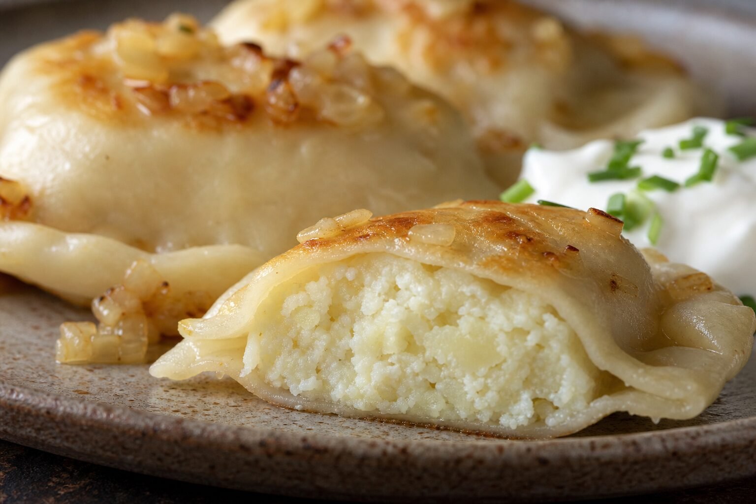 A cut-open pierogi ruskie showing potato and farmer-cheese filling.