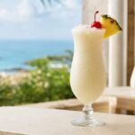 A creamy Puerto Rican pina colada with crushed ice, pineapple wedge, and cocktail cherry.