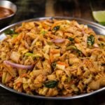 Sri Lankan chicken kottu roti with chopped flatbread, vegetables, egg, and curry leaves.