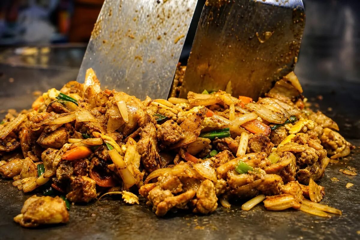 A close-up of Sri Lankan kottu roti with chopped roti, chicken, vegetables, and egg.