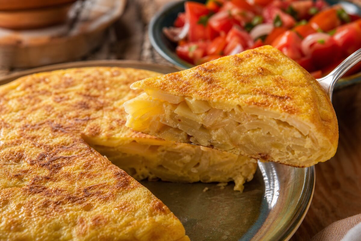 Close serving of Spanish tortilla espanola showing its soft potato and onion center and browned edges.