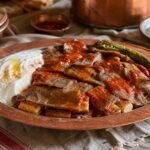 Turkish Iskender kebab with sliced lamb, toasted pide, tomato sauce, browned butter, and yogurt.