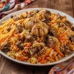 A platter of Uzbek plov with fluffy rice, tender lamb, carrots, garlic, and herbs.