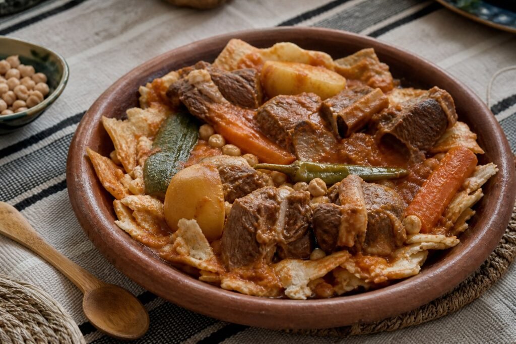 Algerian chakhchoukha with torn rougag, lamb, chickpeas, potatoes, carrots, zucchini, and tomato broth.