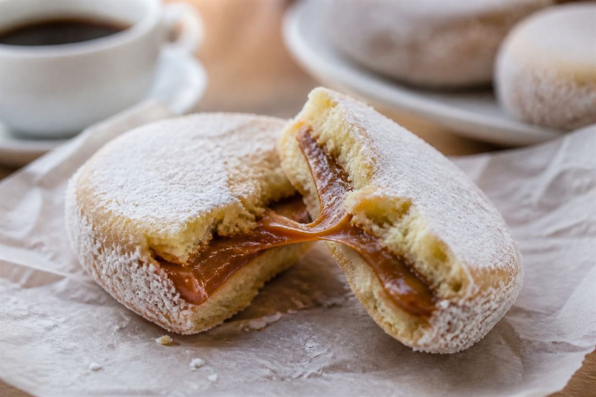 An Argentine alfajor separated to show its thick dulce de leche filling.