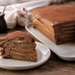 A slice of Argentine chocotorta showing chocolate biscuit and dulce de leche layers.