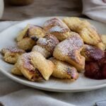 Austrian kaiserschmarrn pancake pieces with powdered sugar and plum compote.