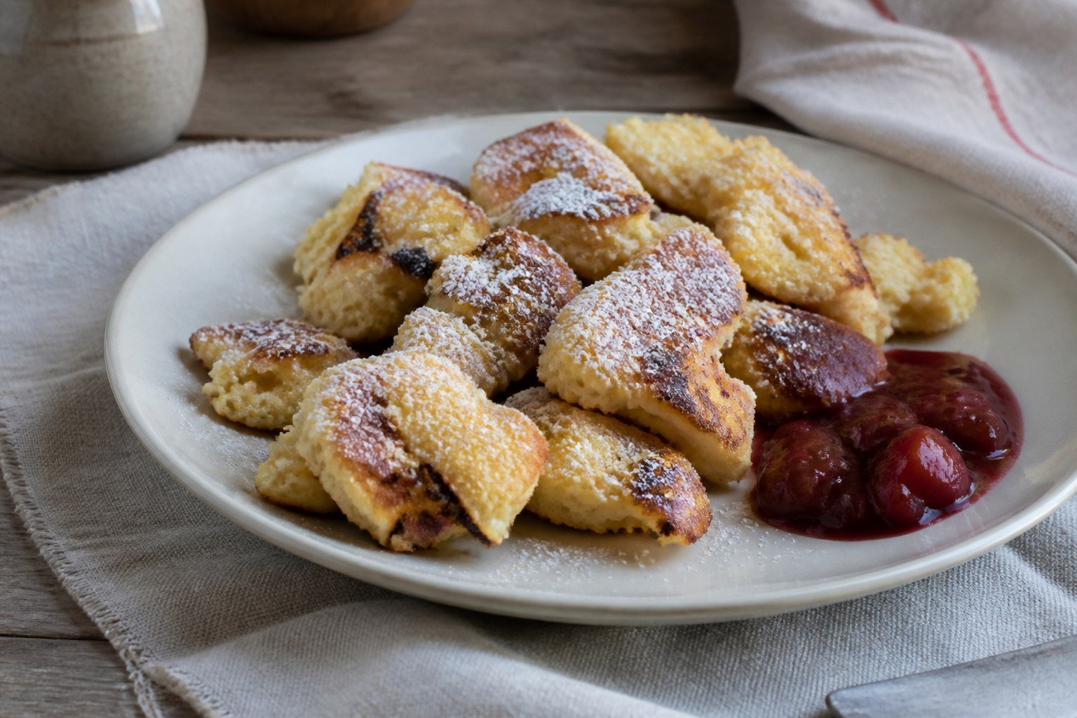 Austrian kaiserschmarrn pancake pieces with powdered sugar and plum compote.