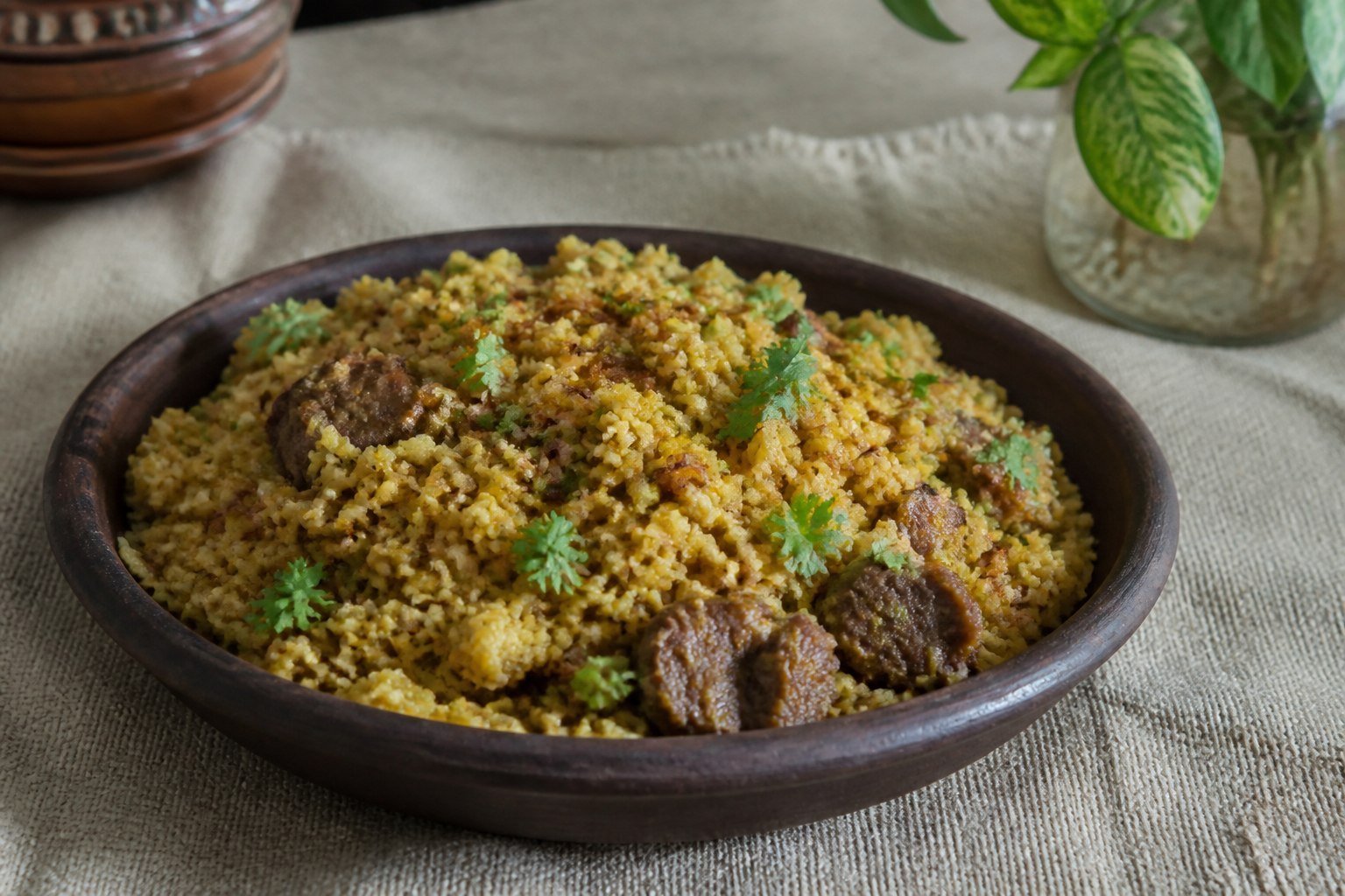 Bangladeshi bhuna khichuri with golden rice, moong dal, beef, fried onion, and cilantro.