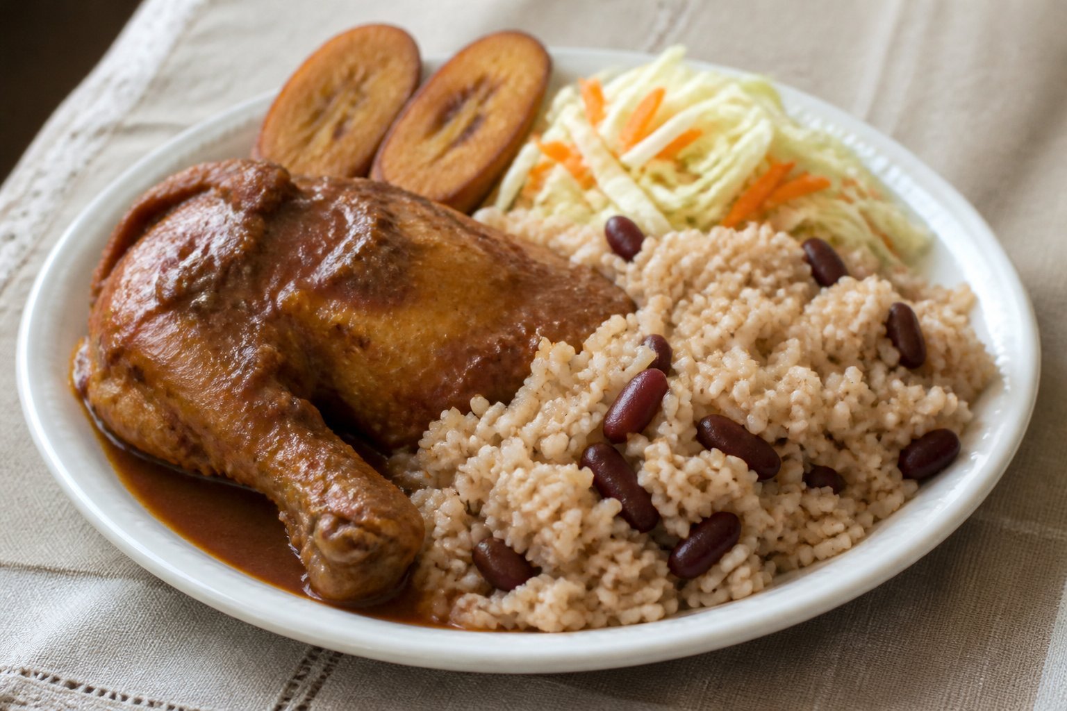 Belizean red recado stew chicken served with coconut rice and beans, slaw, and plantain.