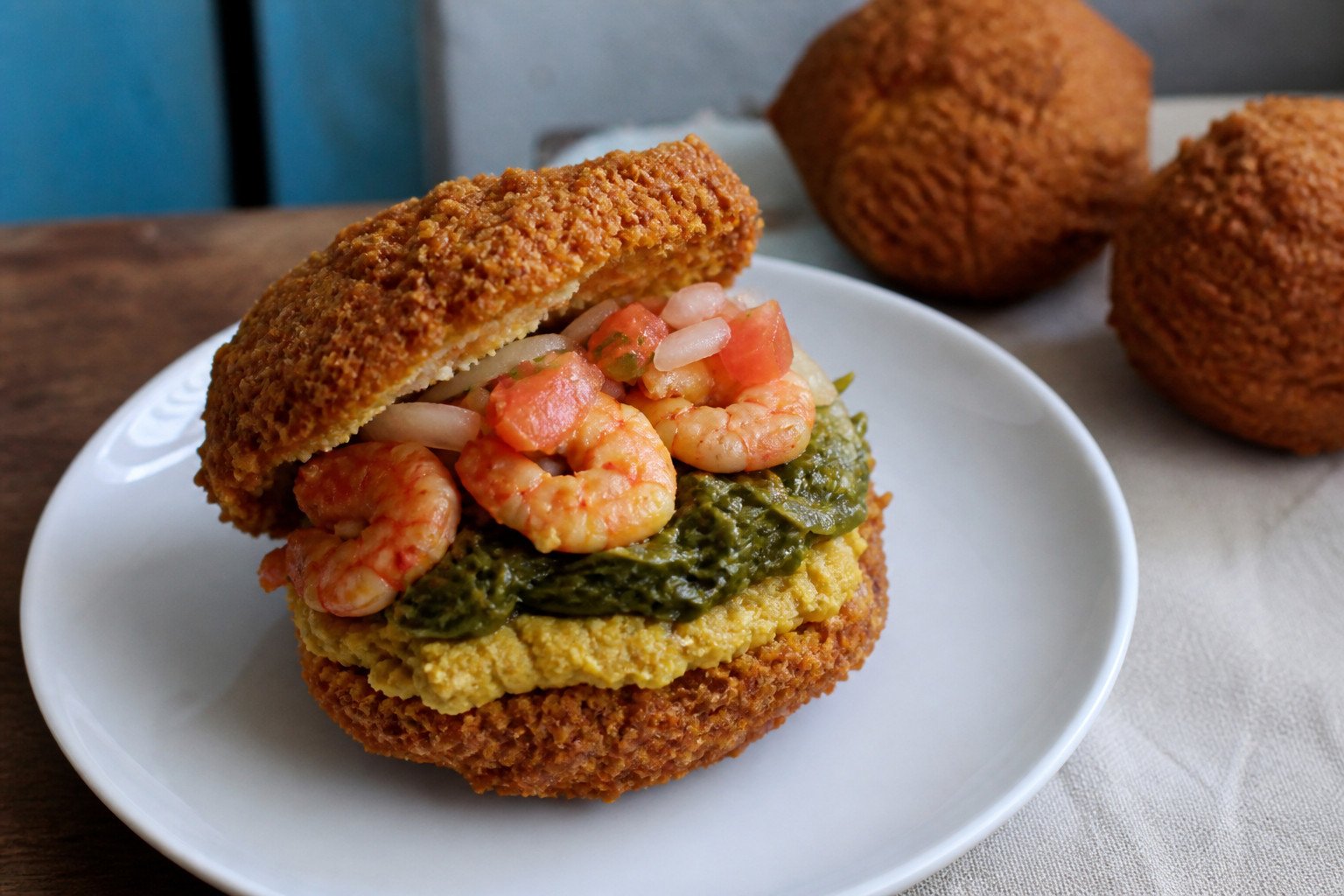 A close serving view of one Brazilian acaraje with traditional fillings.
