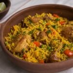 Brazilian galinhada with golden rice, chicken, peas, carrots, and peppers.