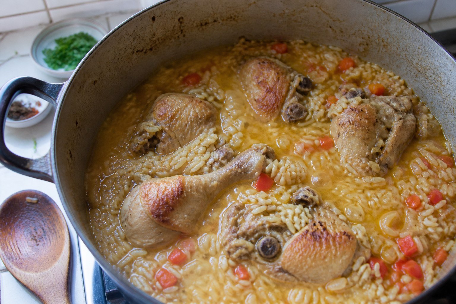Bone-in chicken and rice simmering together in a heavy pot for Brazilian galinhada.