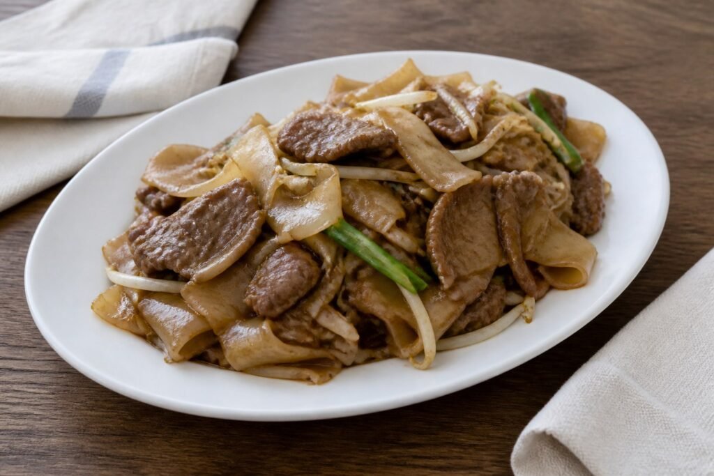 Cantonese beef chow fun with broad rice noodles, bean sprouts, and scallions.