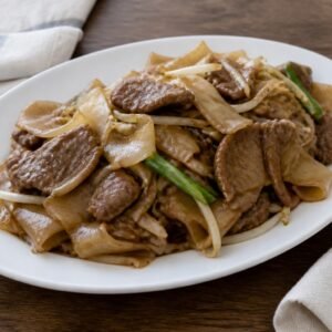 Cantonese beef chow fun with broad rice noodles, bean sprouts, and scallions.
