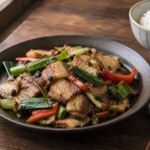 Sichuan twice-cooked pork with green garlic, peppers, and rice.