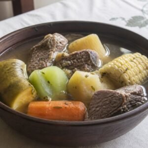 Costa Rican olla de carne with beef, yuca, plantain, corn, potato, chayote, carrot, and clear broth.