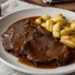 Croatian pasticada sliced in red wine sauce with potato gnocchi.