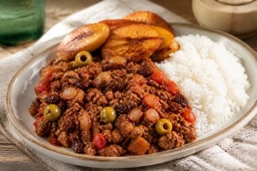 Cuban picadillo with ground beef, tomato sauce, olives, raisins, white rice, and fried plantains.