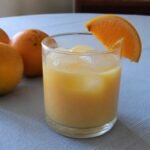 Dominican morir sonando, a creamy orange and milk drink served cold with ice and an orange slice.