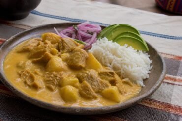 Ecuadorian guatita tripe and potato stew with rice, avocado, and pickled onion.