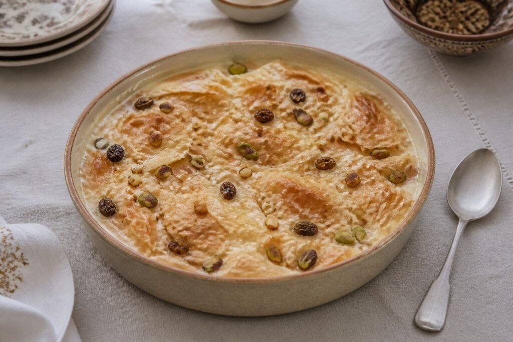 Egyptian Om Ali puff-pastry pudding baked with milk, raisins, almonds, and pistachios.