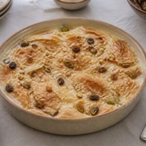 Egyptian Om Ali puff-pastry pudding baked with milk, raisins, almonds, and pistachios.