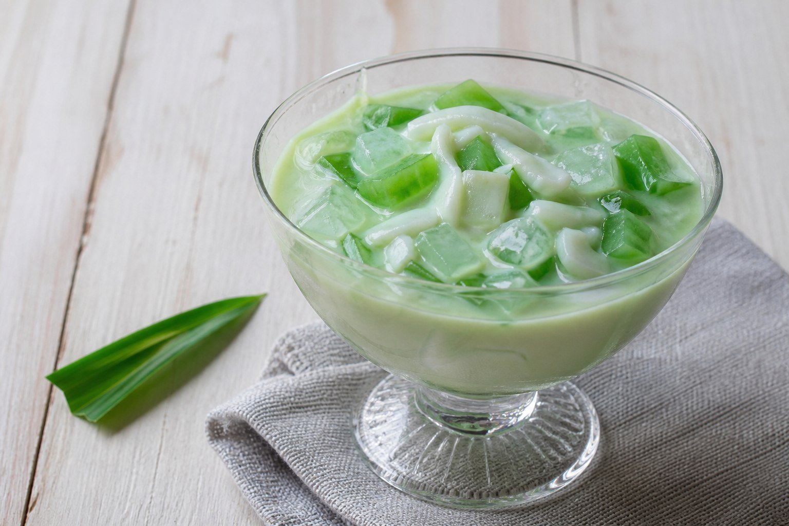 Filipino buko pandan dessert with young coconut and green pandan jelly.