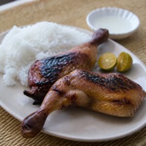 Filipino chicken inasal with steamed rice, calamansi, and vinegar.