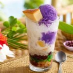 Colorful Filipino halo-halo with shaved ice, ube, fruit, beans, and leche flan.